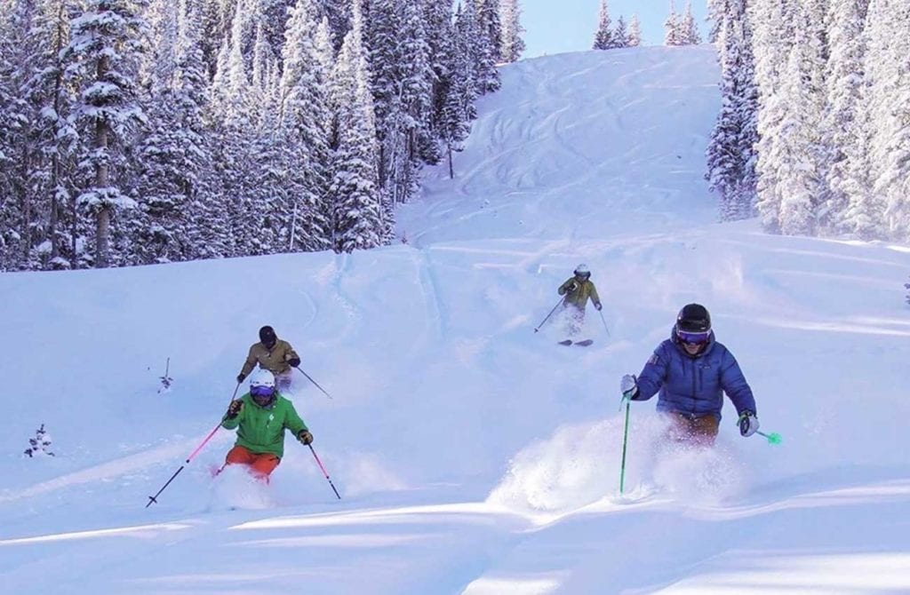 Four skiiers coming down hill at Angel Fire Ski Resort