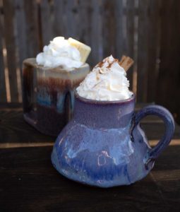 Two mugs of hot cocoa with whipped cream