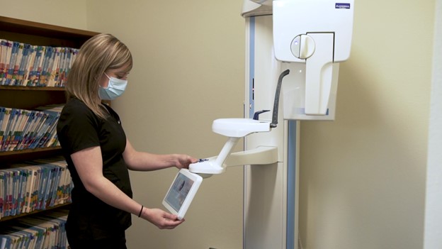 dental assistant working with dental machinery