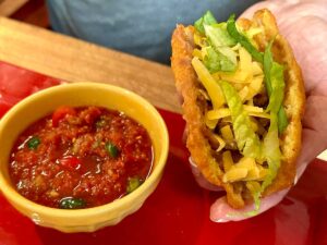 Topping the gorditas with cheese and lettuce with salsa ready to use.