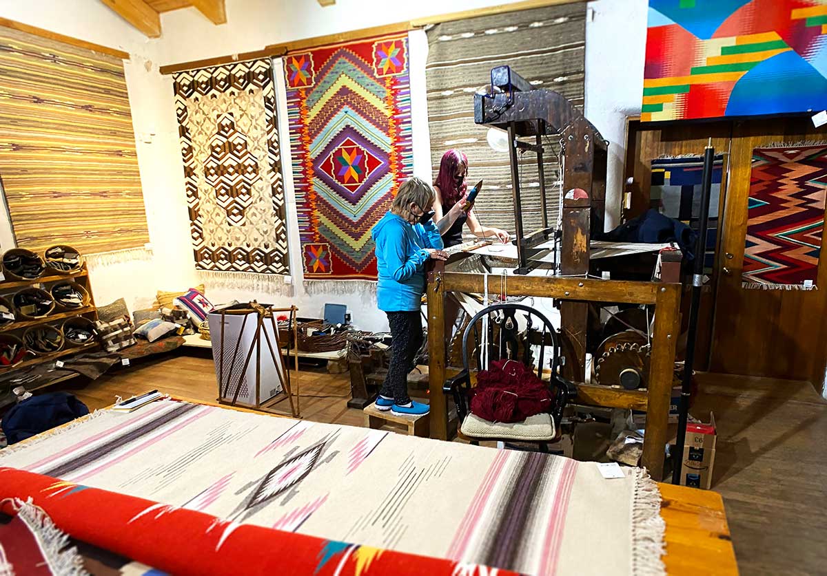 Kathy Trujillo teaches Judie Fein how to weave. Photo by Paul Ross.