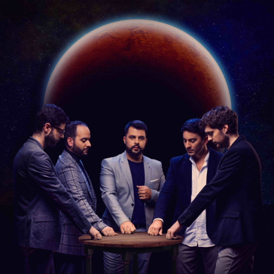 Five men in suits stand around a round table against a space backdrop, with a large red planet looming behind them.
