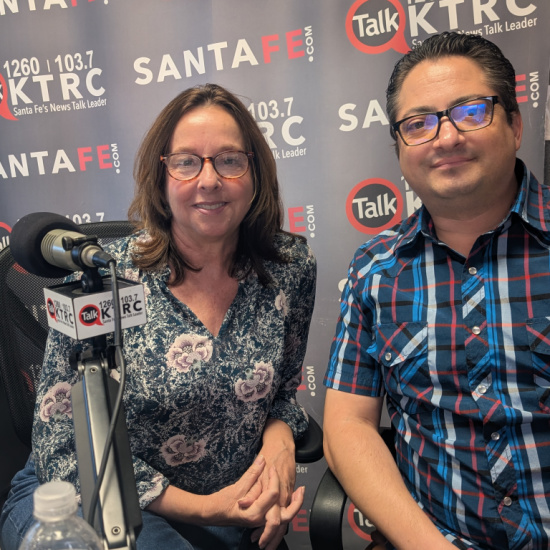 Two radio hosts sit in a recording studio with microphones and a branded backdrop featuring 'KTRC' and 'Talk' logos.